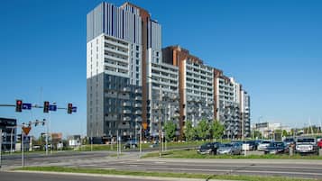 Un edificio residencial de varios pisos con un diseño arquitectónico moderno, que presenta balcones y una combinación de diseños de ventanas.