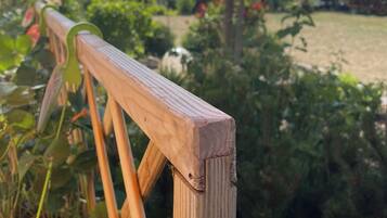Eine Holzhandläufe mit Blick auf einen Garten und Bäume.