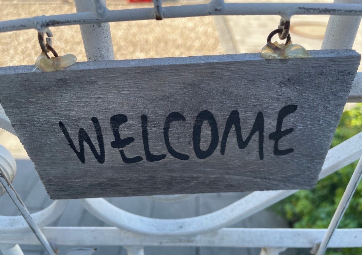 Une pancarte en bois sur laquelle est écrit le mot « BIENVENUE ».
