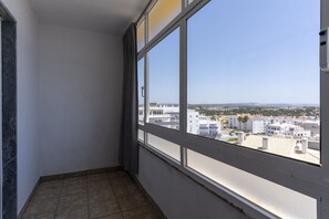 A corner room with a large window overlooking a cityscape. - #415 Charming Apartment | Albufeira (Albufeira)