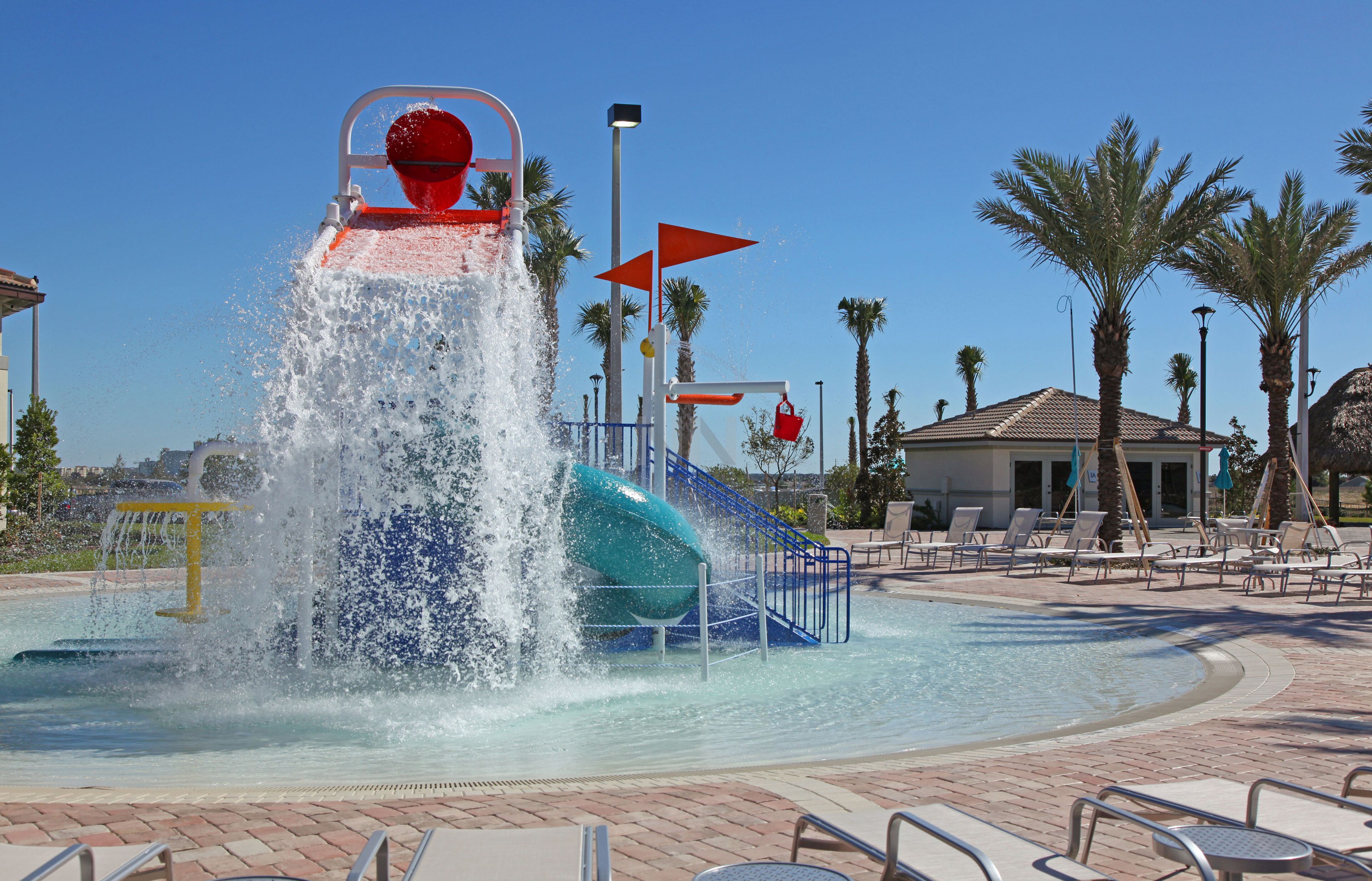 Een waterpark met een lange glijbaan en een zwembadgedeelte met ligbedden.