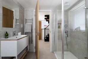 A modern bathroom with a shower, a sink, and a towel rack. - The Old Abattoir -  an apartment that sleeps 2 guests  in 1 bedroom (Chipping Campden)