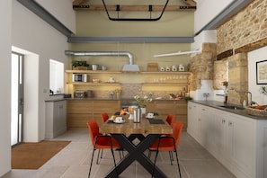 A modern kitchen with a central island, wooden cabinets, and a stone accent wall. - The Old Abattoir -  an apartment that sleeps 2 guests  in 1 bedroom (Chipping Campden)