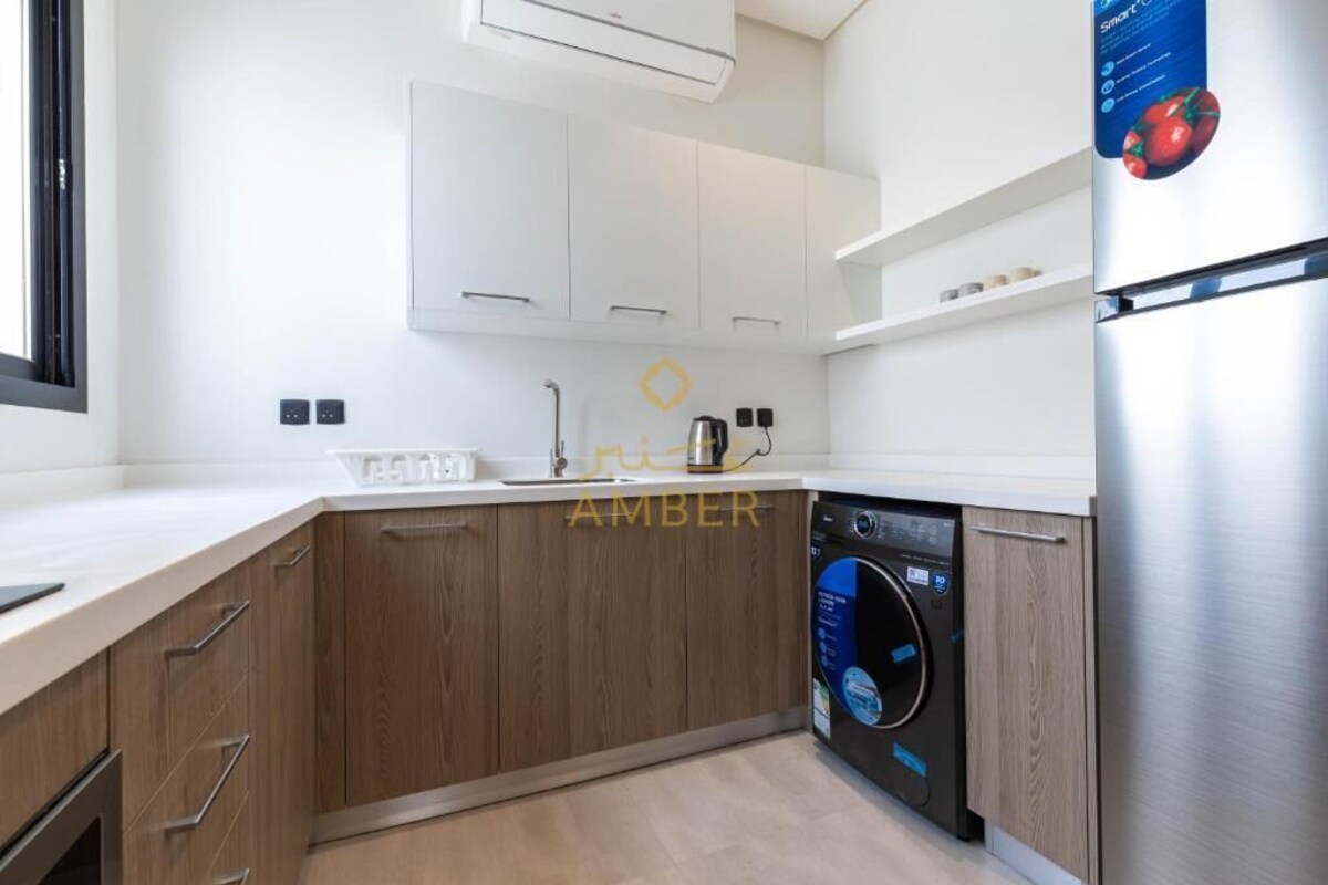 Eine moderne Küche mit Holzschränken, einem integrierten Geschirrspüler und einem Edelstahl-Kühlschrank.