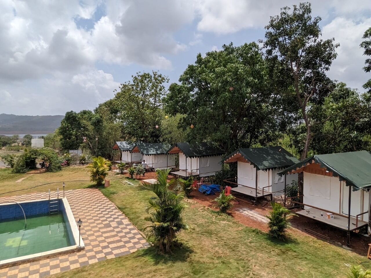 A campsite with several tents, a swimming pool, and a checkered pathway.