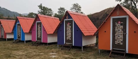 Una hilera de edificios pequeños y coloridos de un piso, con tejados rojos, probablemente usados como alojamiento temporal.