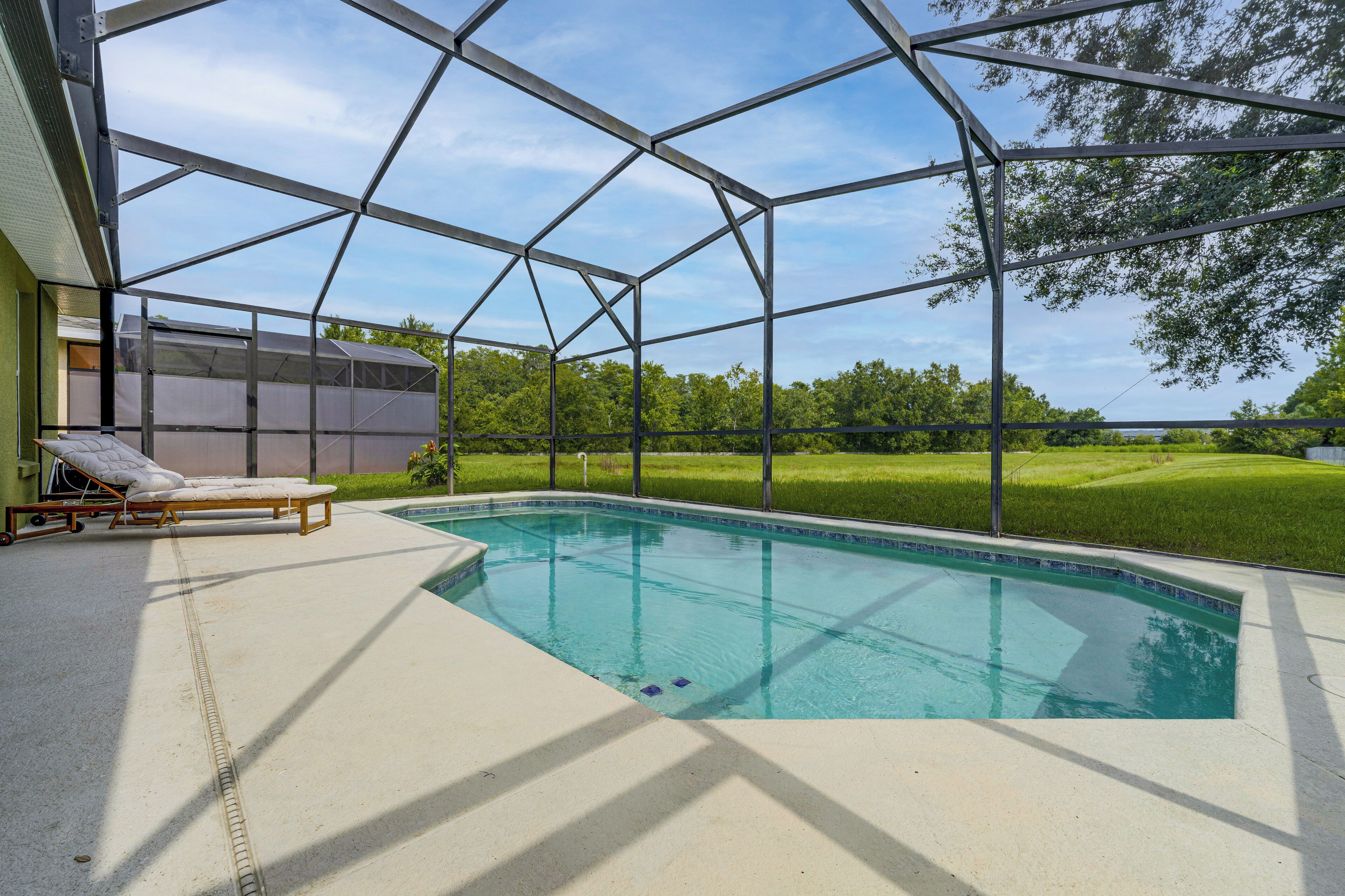 A swimming pool with a clear view of the sky and surrounding greenery.