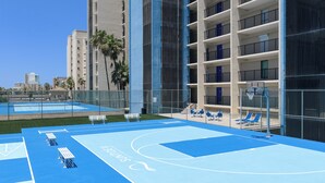 A basketball court with blue flooring, white benches, and a basketball hoop. - All-suite 3br, Gulf Views: Suntide III - Unit 208 (South Padre Island)