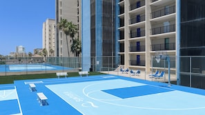 A basketball court with blue flooring, white benches, and a basketball hoop. - All-suite 3br, Gulf Views: Suntide III - Unit 208 (South Padre Island)