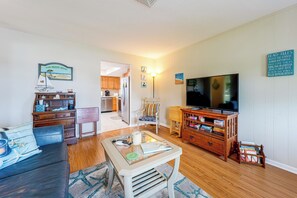 A living room with a television, wooden furniture, and a kitchen in the background. - 10 Mins to Beach! Largo Duplex w/ Shared Pool (Largo)