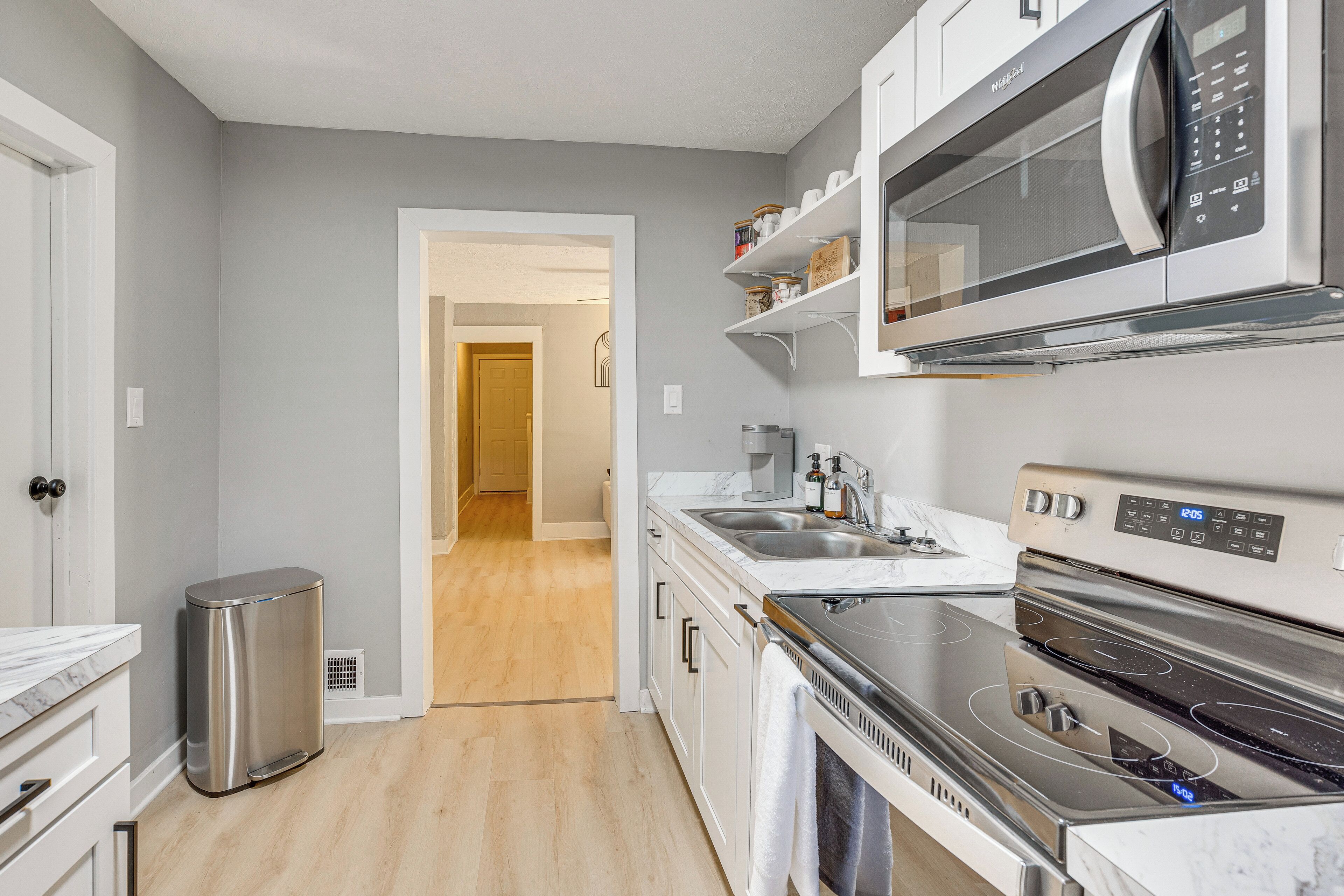 Una cucina moderna con piano cottura in acciaio inossidabile, forno a microonde e forno integrato.