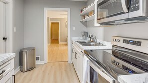Una cocina moderna con estufa de acero inoxidable, microondas y horno empotrado.
