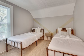 A bedroom with two single beds, a nightstand, and a window with blinds. - Walk to University of Akron! Game Day Getaway (Akron)