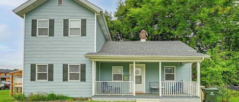 A two-story house with a front porch, a chimney, and a mailbox.