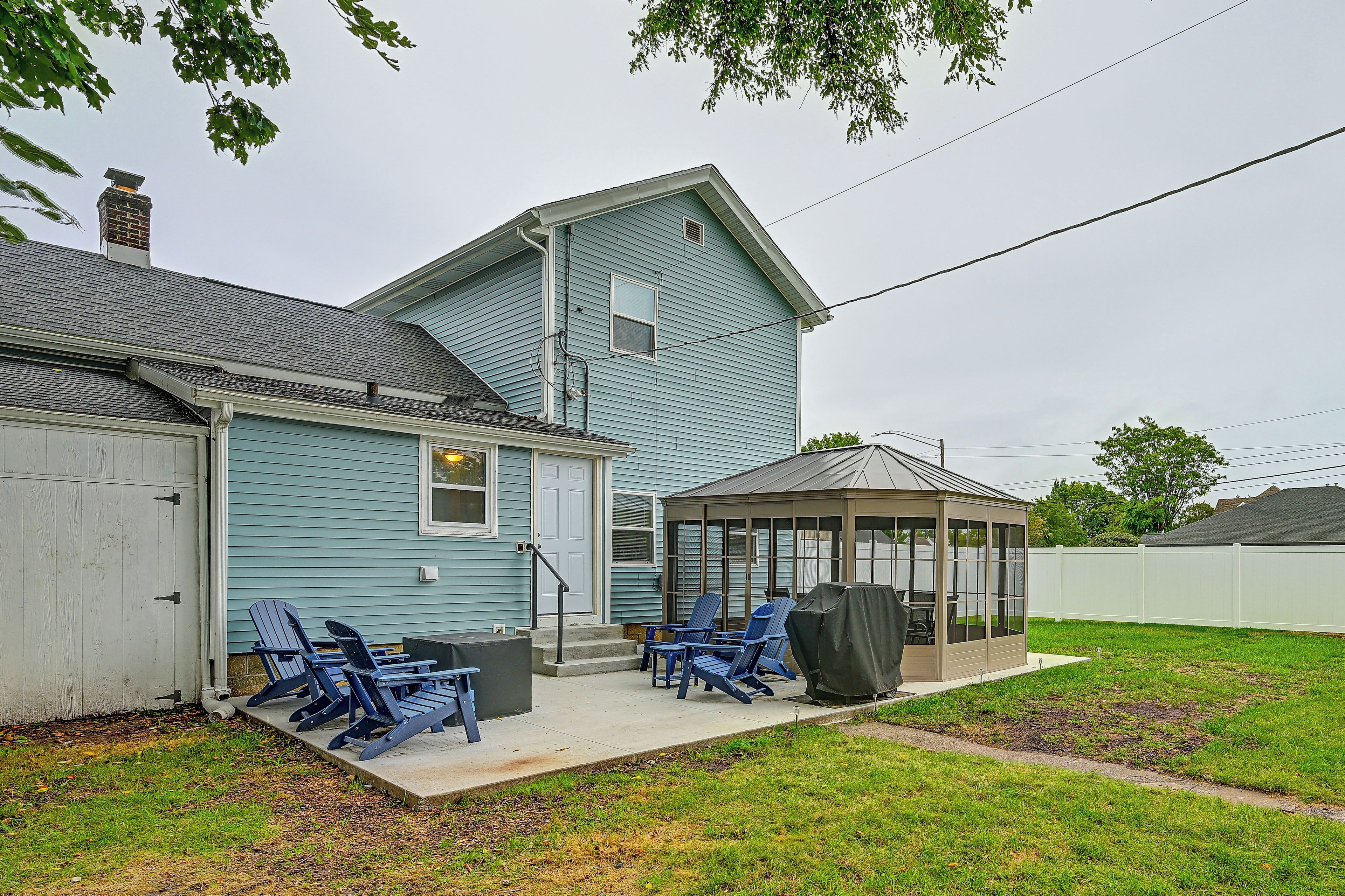 A house with a covered patio area, outdoor seating, and a garage.