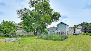 A residential area with houses, a fenced yard, and a clear sky.