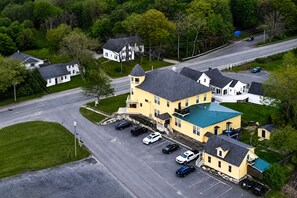 A large yellow building with a green roof, surrounded by a parking lot and a road. - Near Bates & Bowdoin Colleges + Local Nature Park! (Lisbon)