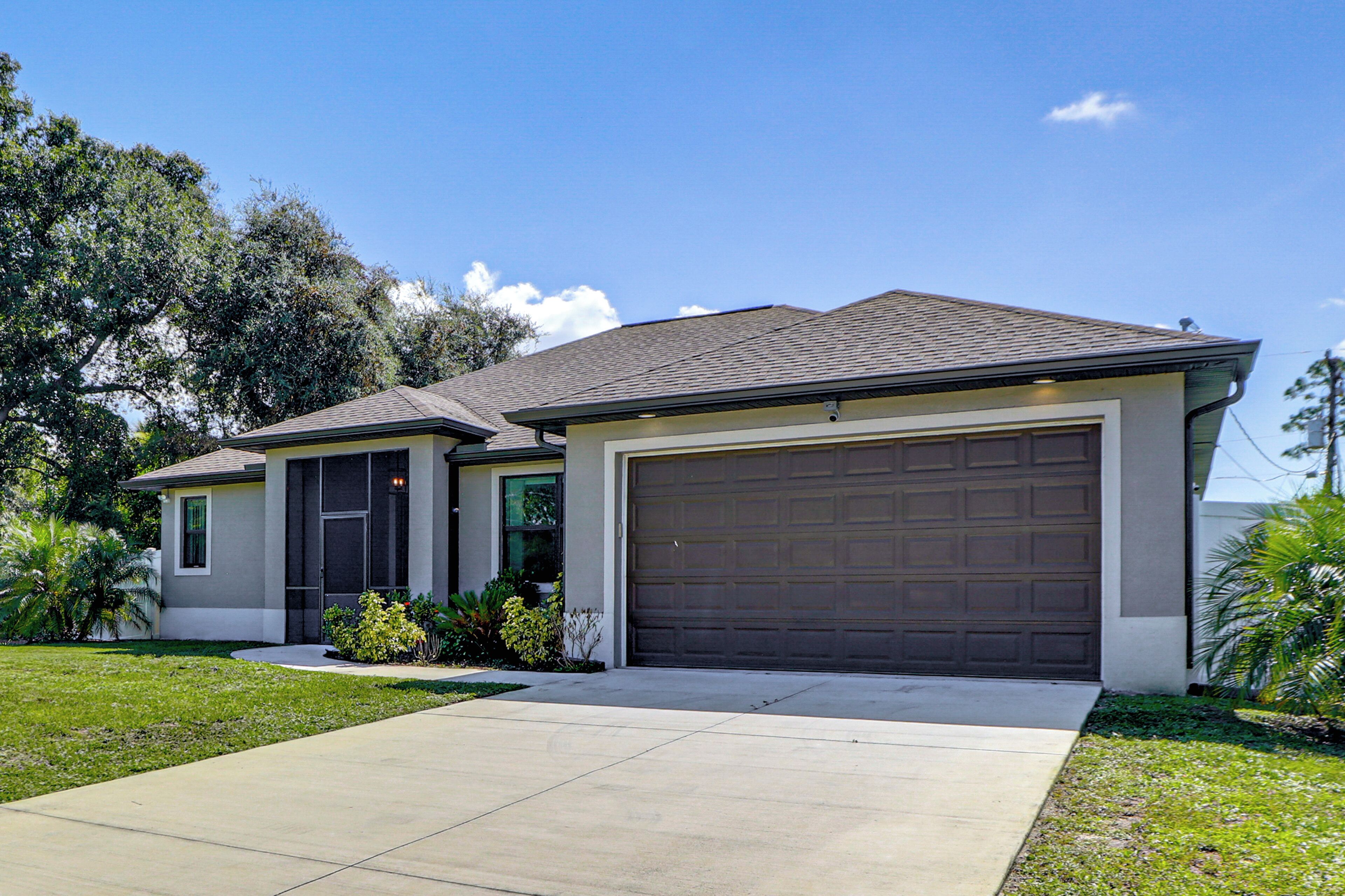 A residential house with a garage, a driveway, and a lawn.