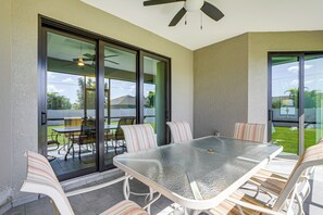 A glass-top table with chairs, a ceiling fan, and a view of the outdoors. - 6 Mi to Port Charlotte Beach Park! Family Getaway (Port Charlotte)