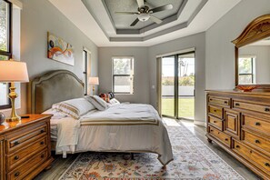 Ein Schlafzimmer mit Bett, Kommode und Deckenventilator.