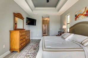 A bedroom with a large bed, a dresser, a television, and a painting on the wall. - 6 Mi to Port Charlotte Beach Park! Family Getaway (Port Charlotte)