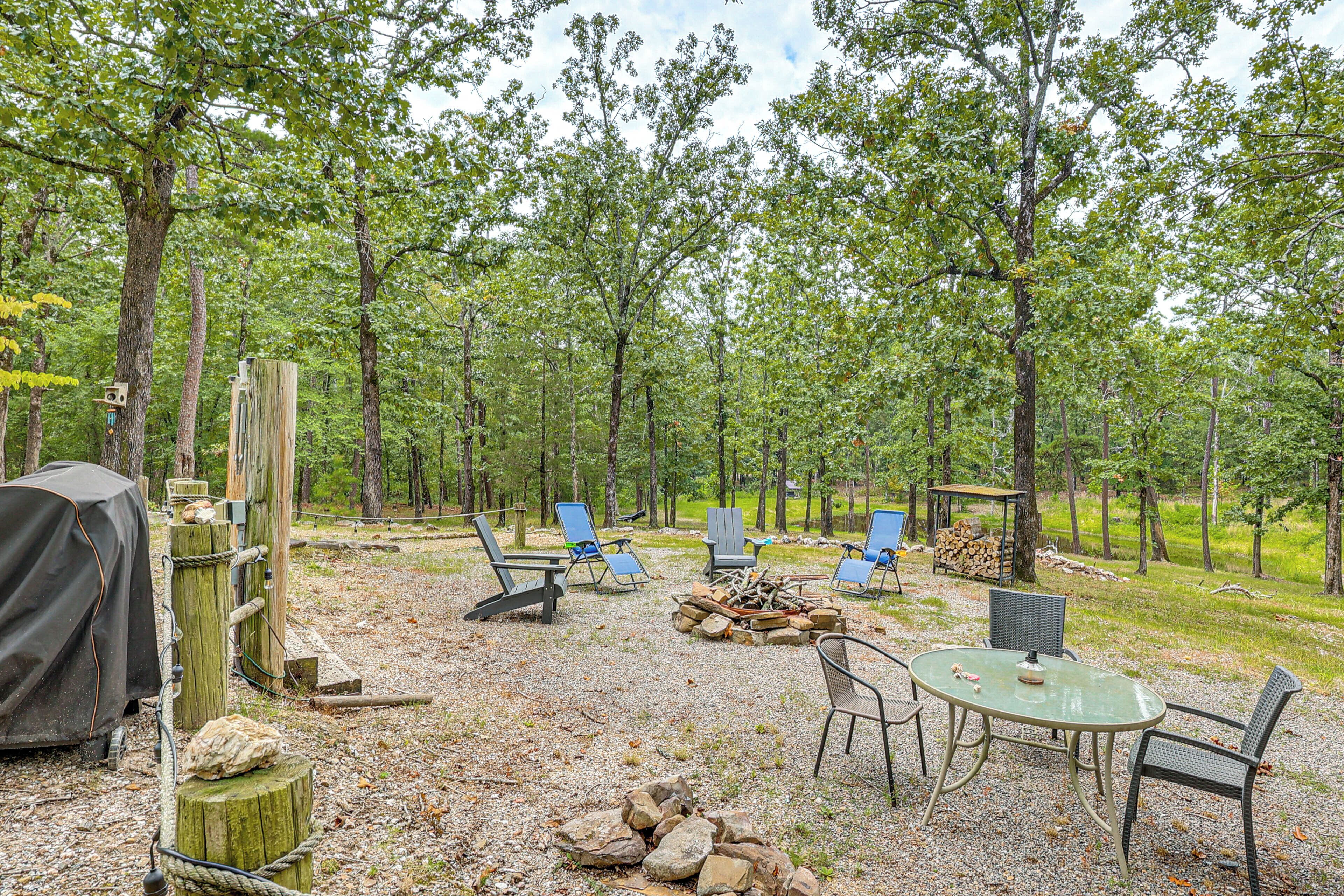 Een camping met buitenzitplaatsen, een vuurkuil en een overdekte barbecuehoek.