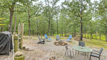 Een camping met buitenzitplaatsen, een vuurkuil en een overdekte barbecuehoek.