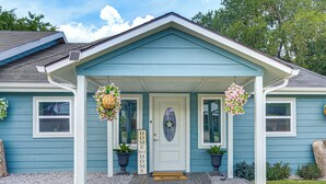 A house with a porch, a welcome sign, and two hanging flower baskets. - Boat Ramp Access! Canalfront Granbury Escape (Granbury)