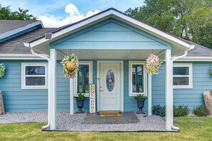 A house with a porch, a welcome sign, and two hanging flower baskets. - Boat Ramp Access! Canalfront Granbury Escape (Granbury)