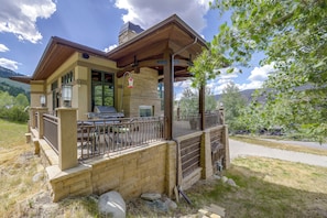 Una casa con patio, parrilla exterior y paredes de piedra.
