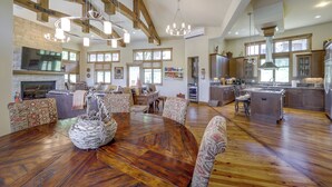 Un amplio espacio de sala con una mesa de comedor de madera, sillas estampadas y una chimenea.
