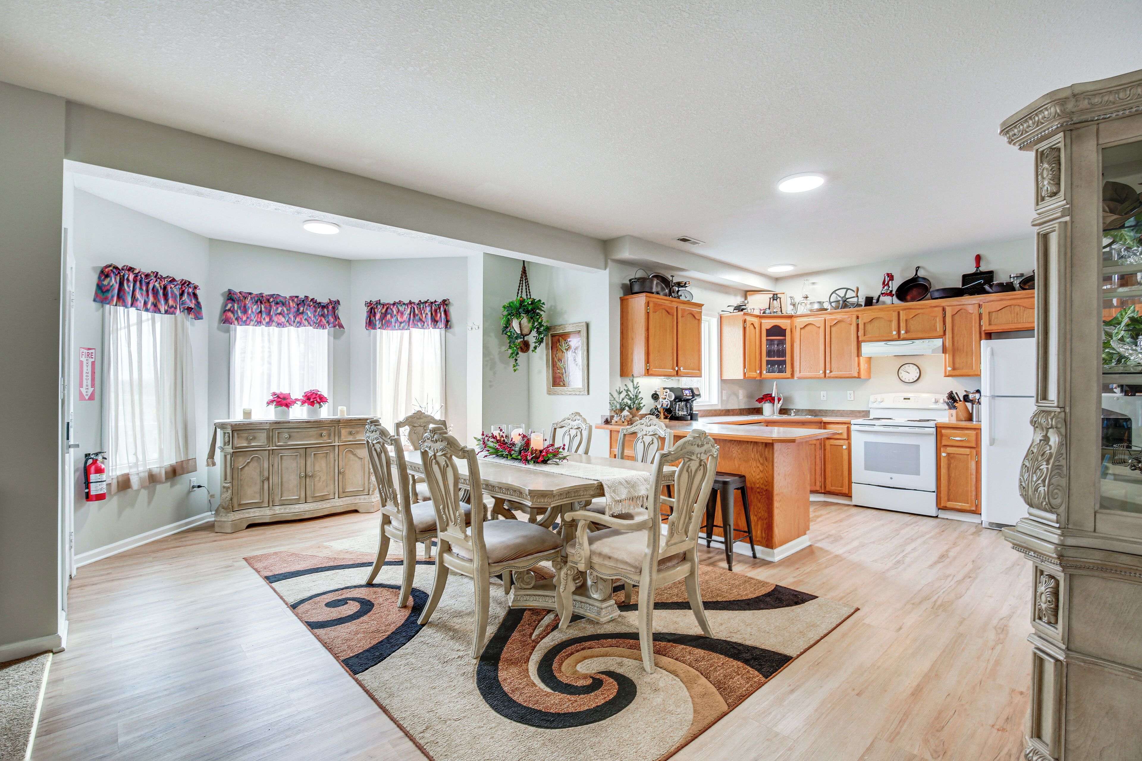 A spacious kitchen with wooden cabinets, a dining area with a table and chairs, and a large island.