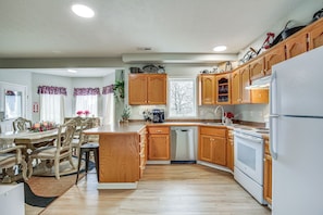 A modern kitchen with wooden cabinets, a dishwasher, and a refrigerator. - Studio Suite & Country Views! Sibley Group Retreat (Sibley)