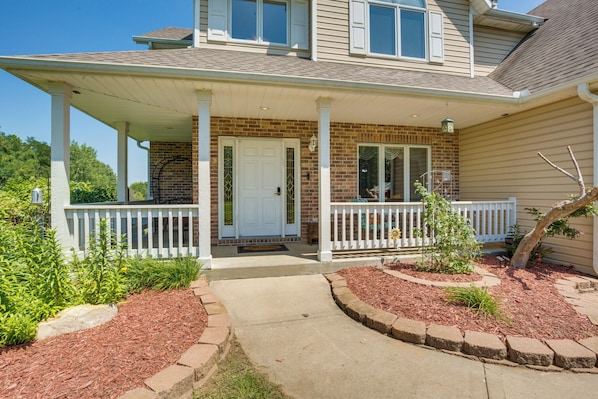 A two-story house with a covered porch, brick exterior, and a front door. - Studio Suite & Country Views! Sibley Group Retreat (Sibley)