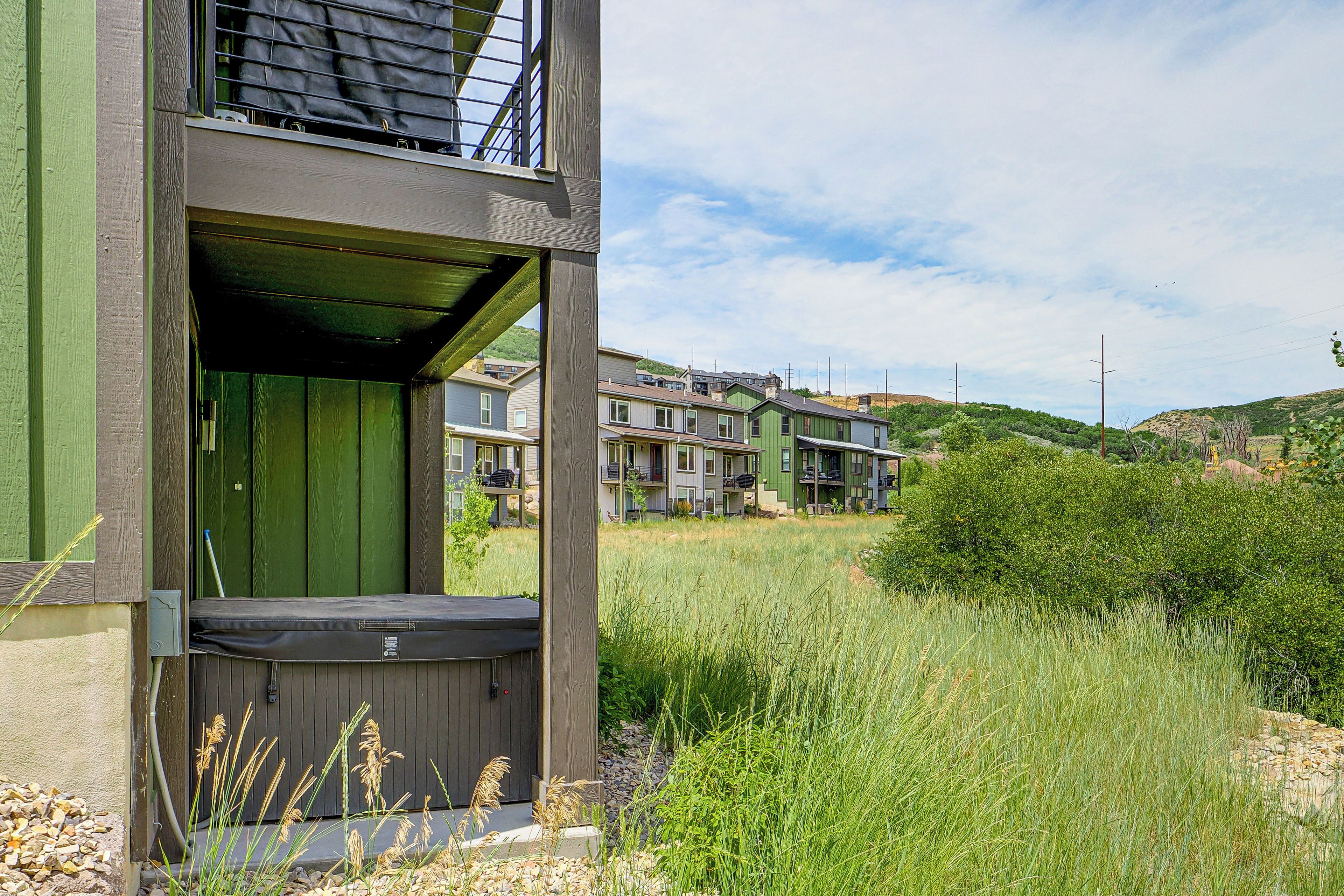 A multi-story building with a green exterior and a balcony.