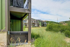 Un edificio de varios pisos con fachada verde y un balcón.
