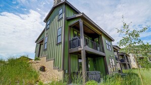 A multi-story building with a green facade, multiple windows, and a balcony. - Hot Tub, Mtn & Lake Views! Group Abode in Daniel (Heber City)