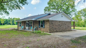 A single-story brick house with a covered porch and a small front yard.