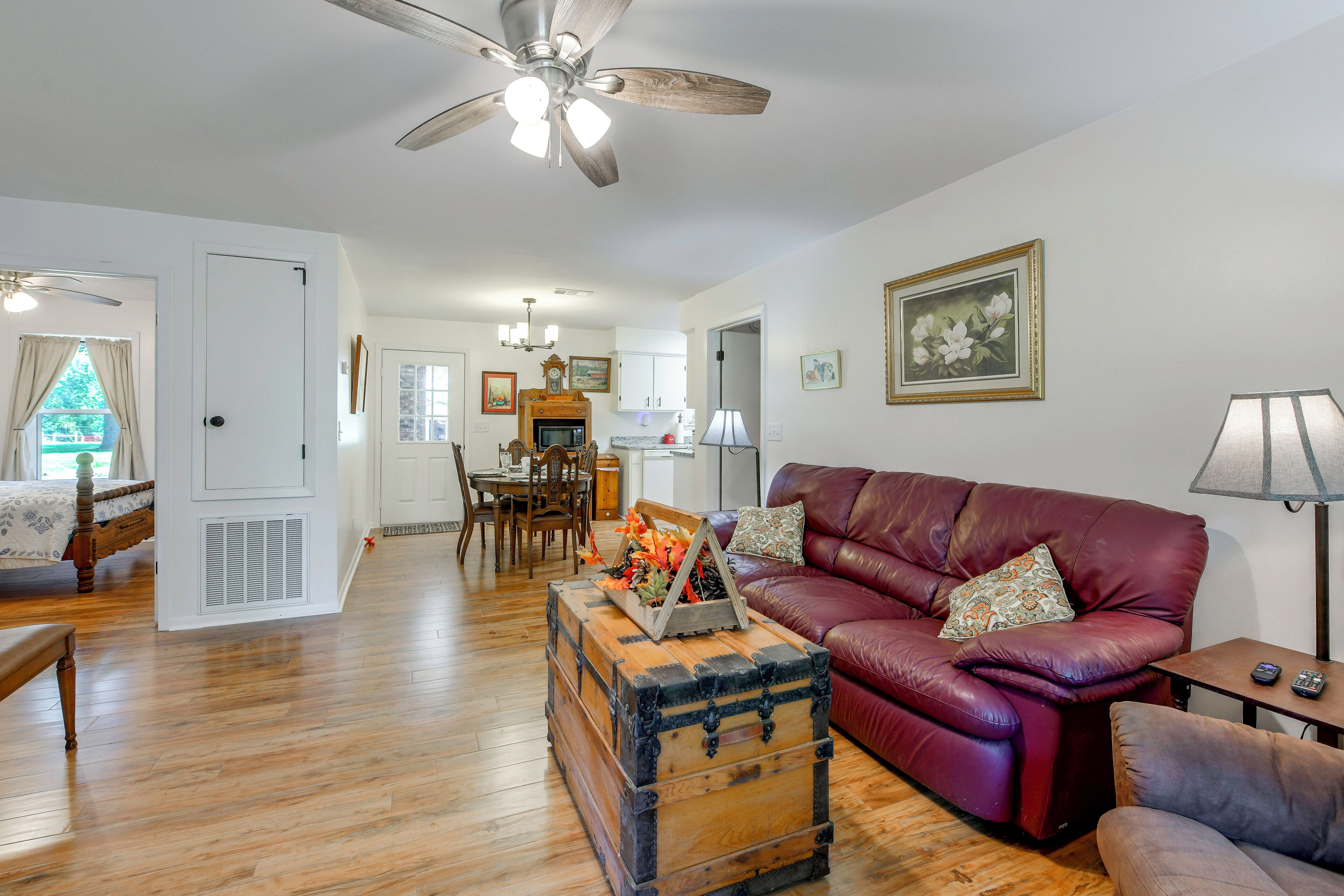 A spacious living room with a leather sofa, a wooden coffee table, and a vintage trunk.