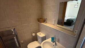 Ein Badezimmer mit Toilette, Waschbecken und einem Spiegel darüber.