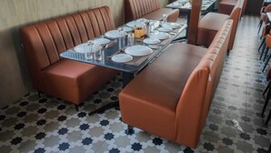 Interior de un restaurante con asientos tipo cabina y piso estampado.