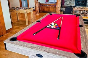 A pool table with a red felt surface and a cue stick with balls. - Two Bears | Mountain Views and Game Nights (Franklin)