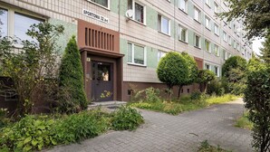 Ein Wohngebäude mit befestigtem Eingangsbereich und einem Schild, das 'SPORTOWA 32 a-c' angibt.