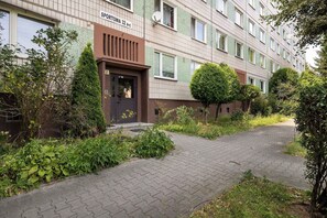 A residential building with a paved entrance and a sign indicating 'SPORTOWA 32 a-c'. - Spacious Apartment with Air Conditioning | Desk | Balcony (Katowice)
