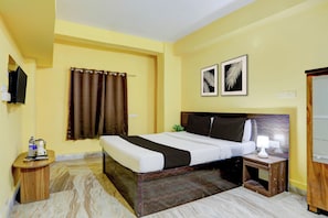 A hotel room with a bed, a bedside table, a lamp, a TV, and two framed pictures on the wall. - Hotel O Palasuni Bridge Bhubaneswar (Bhubaneshwar)