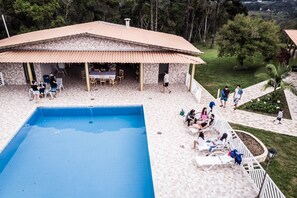 A pool area with a covered patio, outdoor seating, and a view of the surrounding landscape. - Property in Ibiúna with a stunning lake. (Ibiúna)