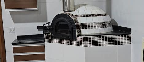 Una cocina con horno empotrado, chimenea y ventana.
