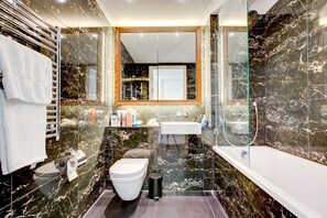 A modern bathroom with a toilet, sink, and bathtub. - Luxury City Apartment in Central London (London)