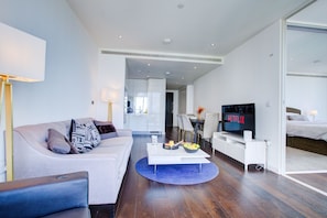 A modern living room with a sofa, coffee table, and a television displaying 'NETFLIX'. - Luxury City Apartment in Central London (London)