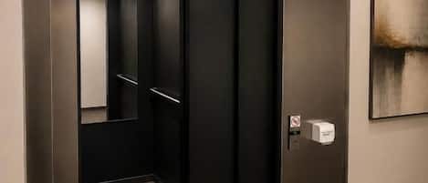 An elevator with a sign indicating the direction to the second floor.